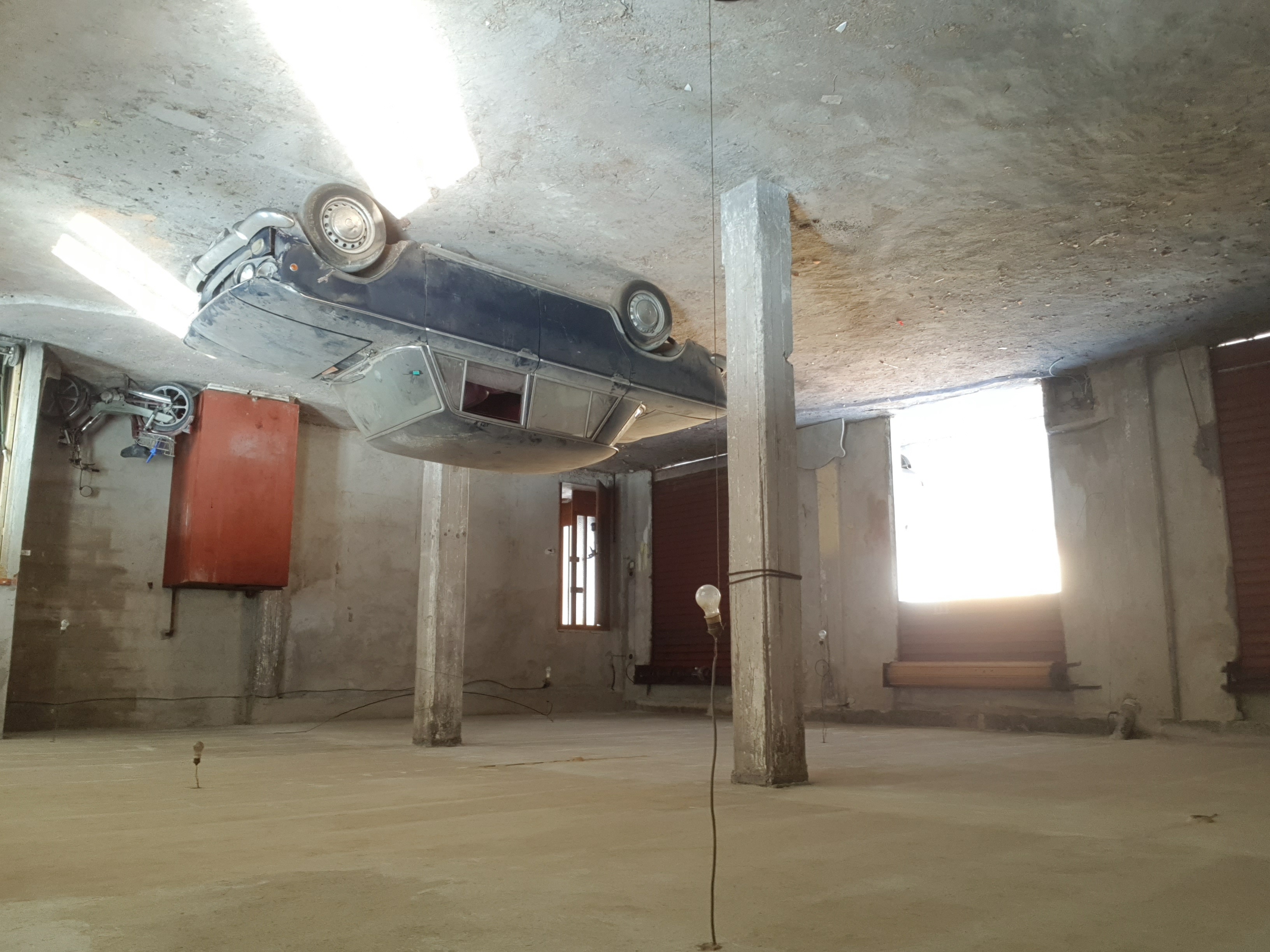 Open door with shaft of light and vintage Fiat